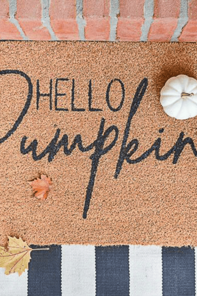 hello pumpkin doormat with a white pumpkin sitting on it