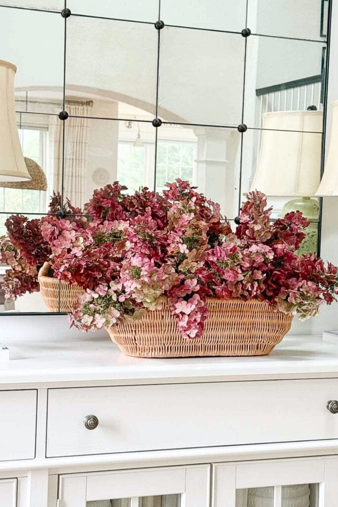 red hydrangeas in a basket on a white buffet