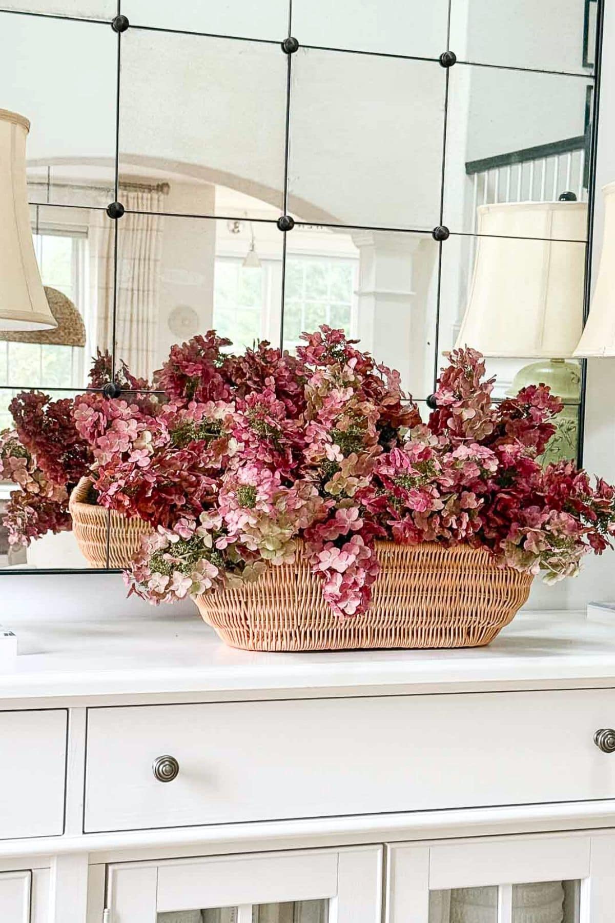 red hydrangeas in a basket on a white buffet
