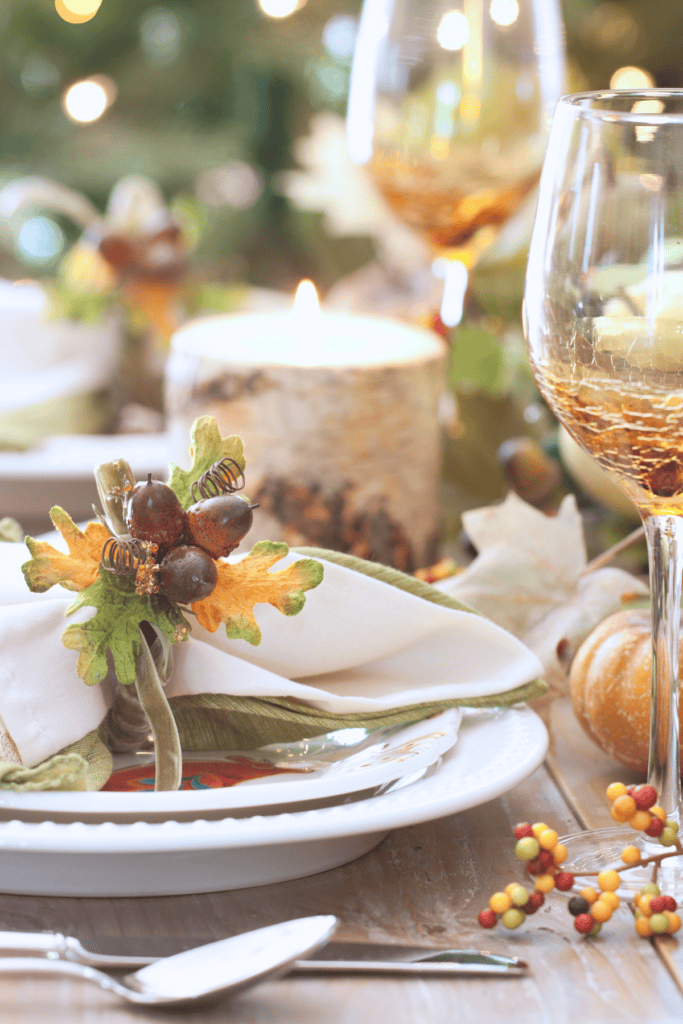 thanksgiving place setting with napkins gathered in an acorn napkin ring.