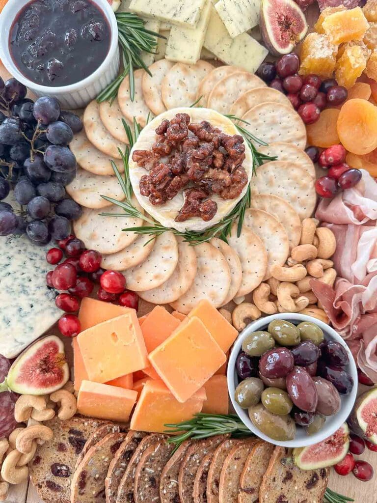 holiday charcuterie board with meats, cheese, fruit, and nuts.