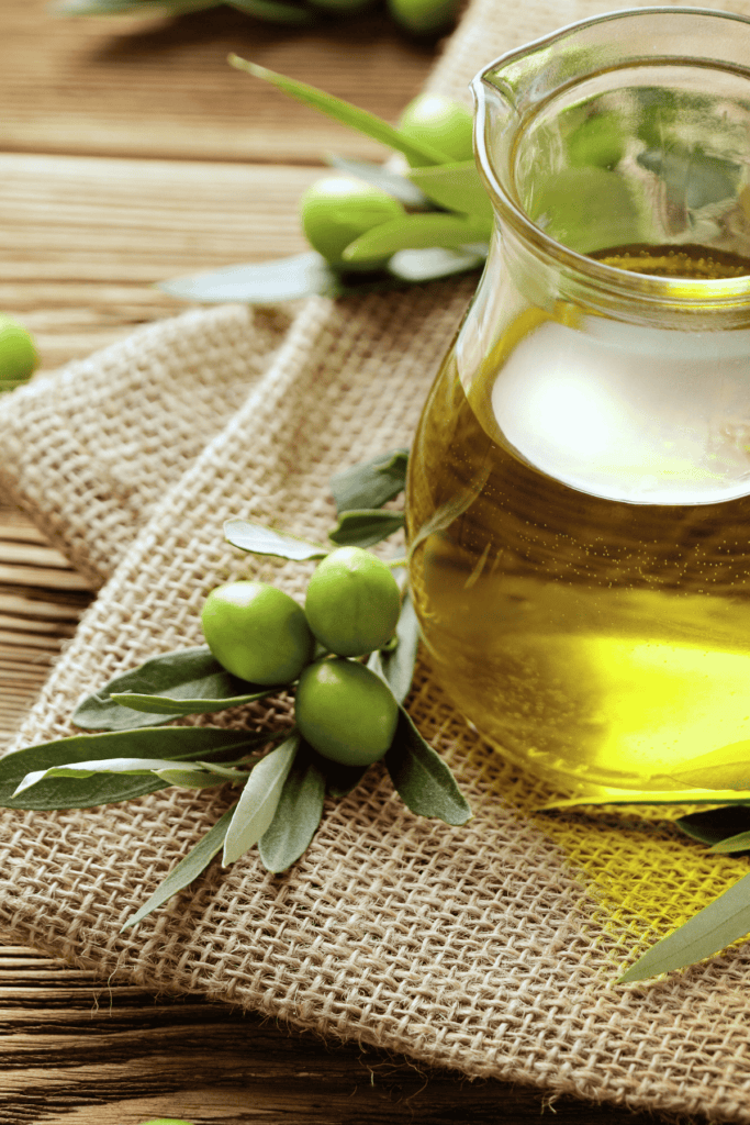 olive oil in a small glass pitchen on a towel