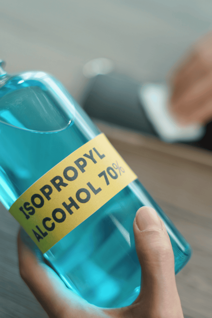 alcohol bottle with someone cleaning with it in the background