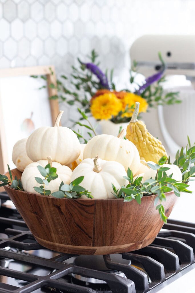 a bowl of white pumpkins on a stove