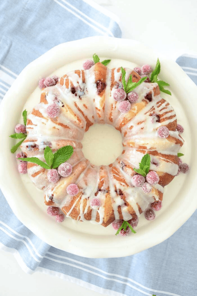 Bundt cake decorated with sugared cranberries and mint