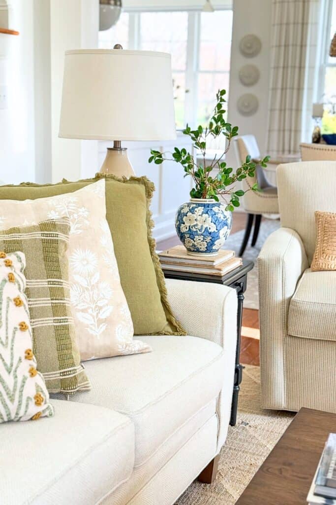 organized living room with styled side table, lamp, books, and vase for a neat and clutter free home