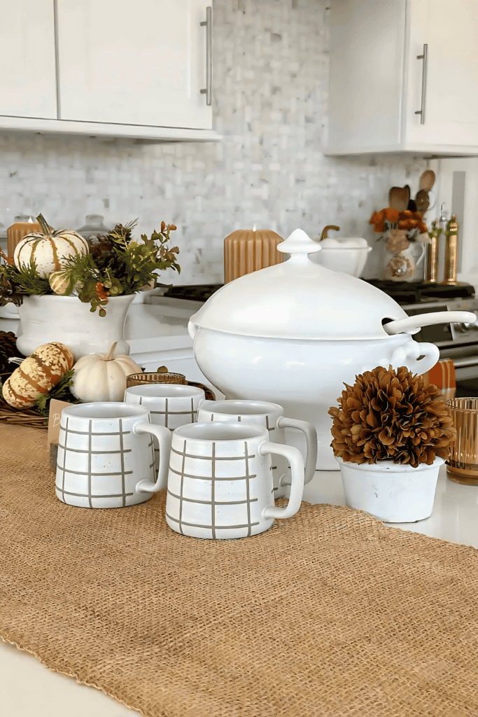 mugs and a white soup tureen on a Thanksgiving buffet