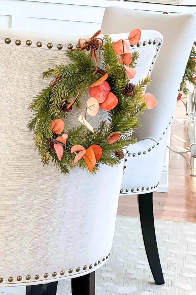 Christmas wreath on the back of a dining chair e