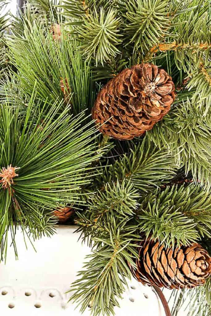close up of faux Christmas greens and pinecones with realistic evergreen needles
