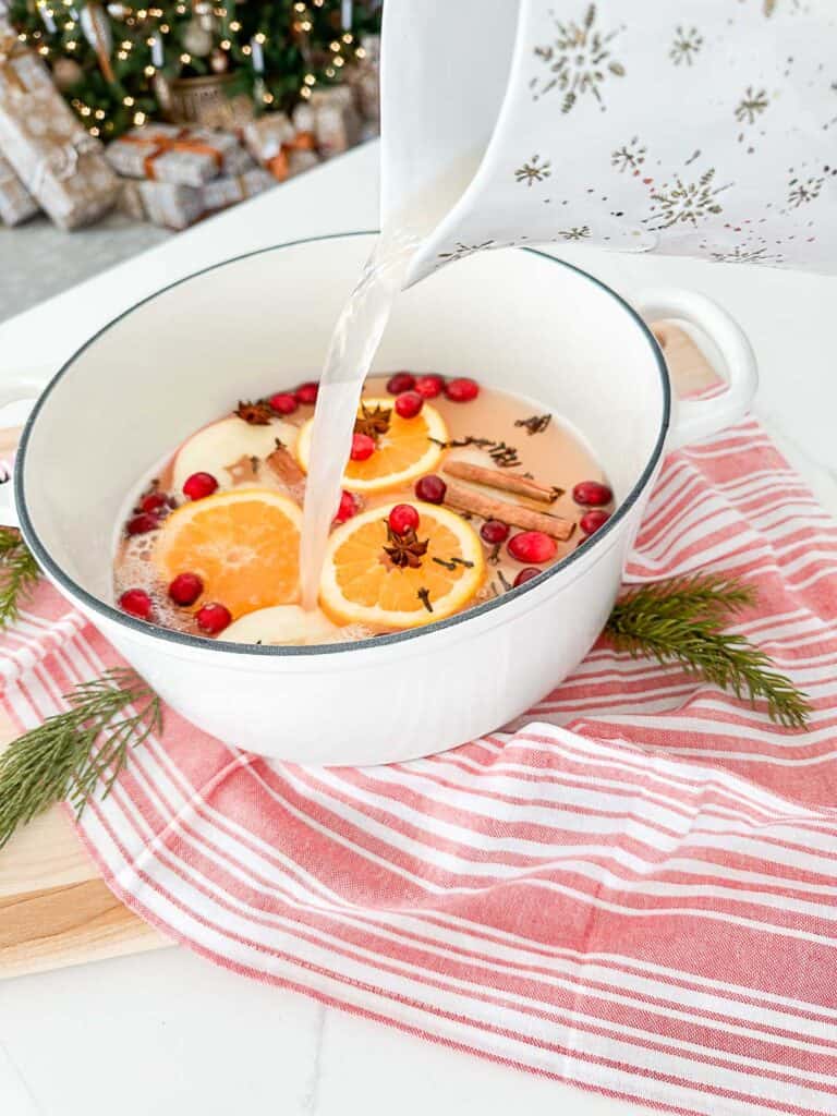 cider being poured into a Dutch oven