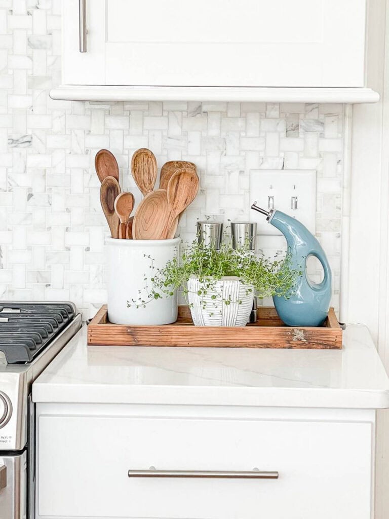 wooden tray with items used to cook next to a stove.