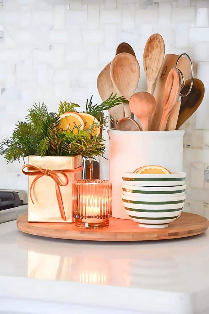 lazy susan with a crock of wooden spoons, and Christmas greens.