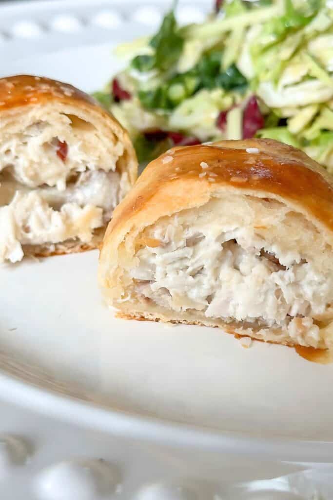 Chicken Crescent Roll Ups on a white plate with a salad