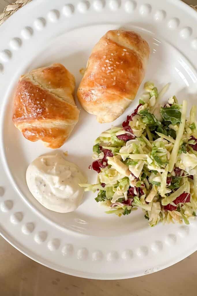 Chicken Crescent Roll Ups on a white plate with a salad