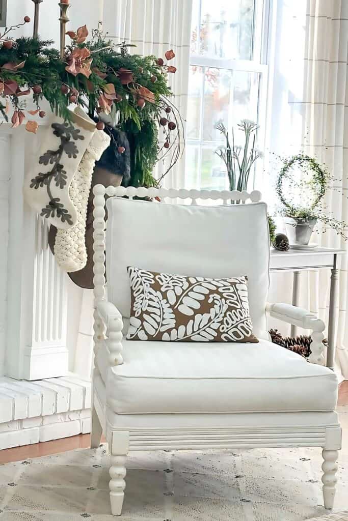 WHITE CHAIR WITH CHRISTMAS MANTEL IN THE BACKGROUND