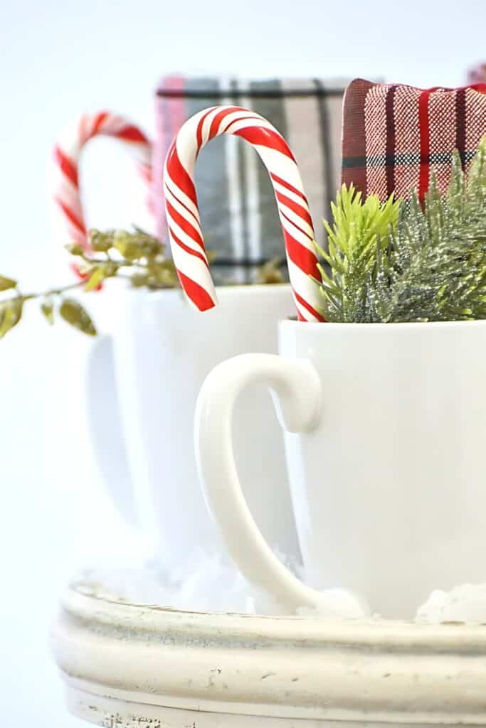 mugs with candy canes, sprigs of evergreens and plaid napkins