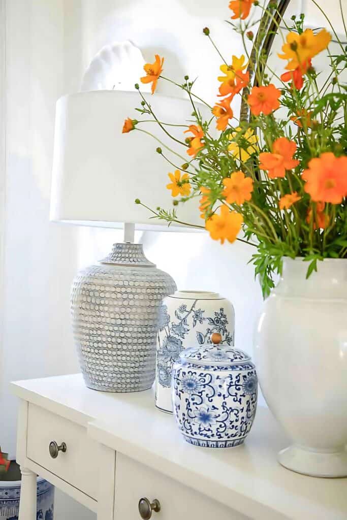 COSMOS IN A WHITE PITCHER ON FOYER TABLE