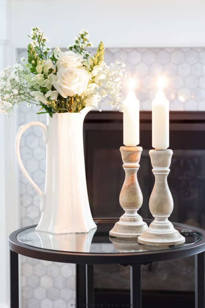 candles and a pitcher of white flowers