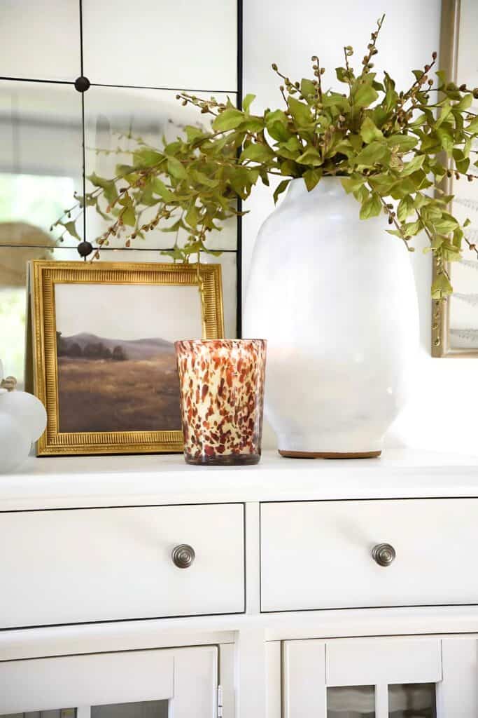 vase of greens on a white buffet