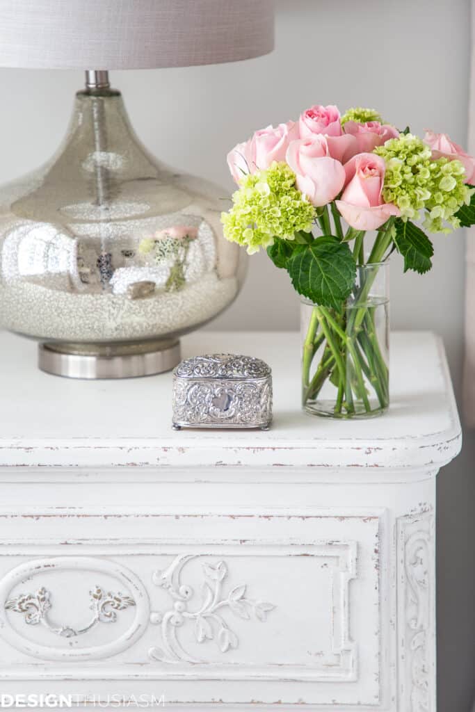 nightstand with a vase of flowers