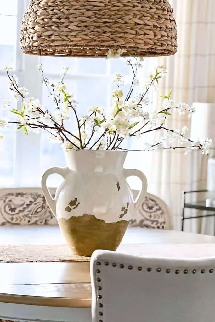 spring branches centerpiece in white rustic vase on dining table