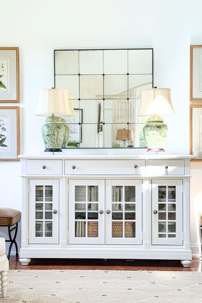 White buffet styled with only a pair of green chinoiserie lamps as anchor decor, before additional styling