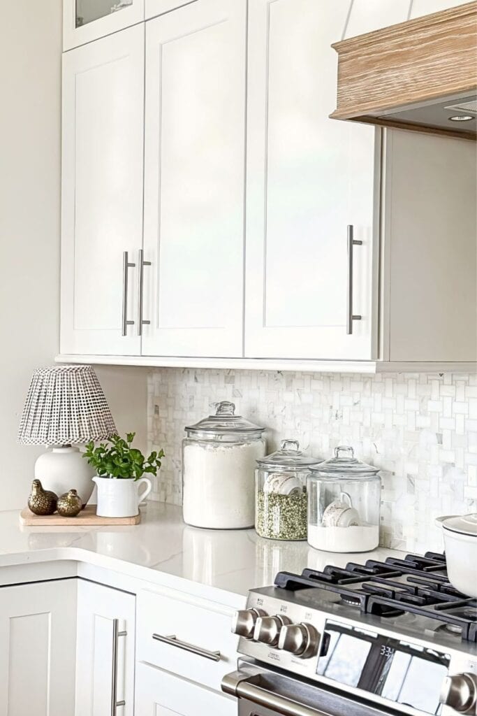 Kitchen countertop decor with glass canisters of flour and beans near the stove