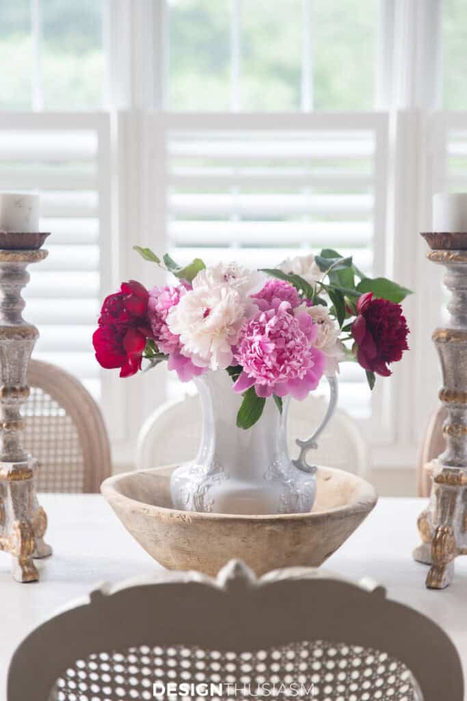 peonies in a white pitcher in a table