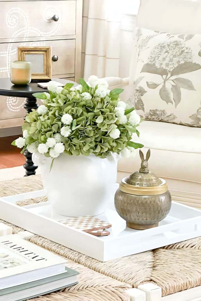 spring living room- green hydrangeas in a white urn on a coffee table