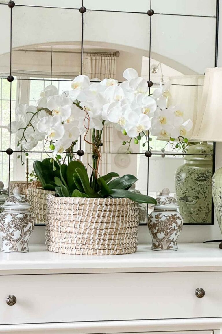 orchids in a basket on a buffet