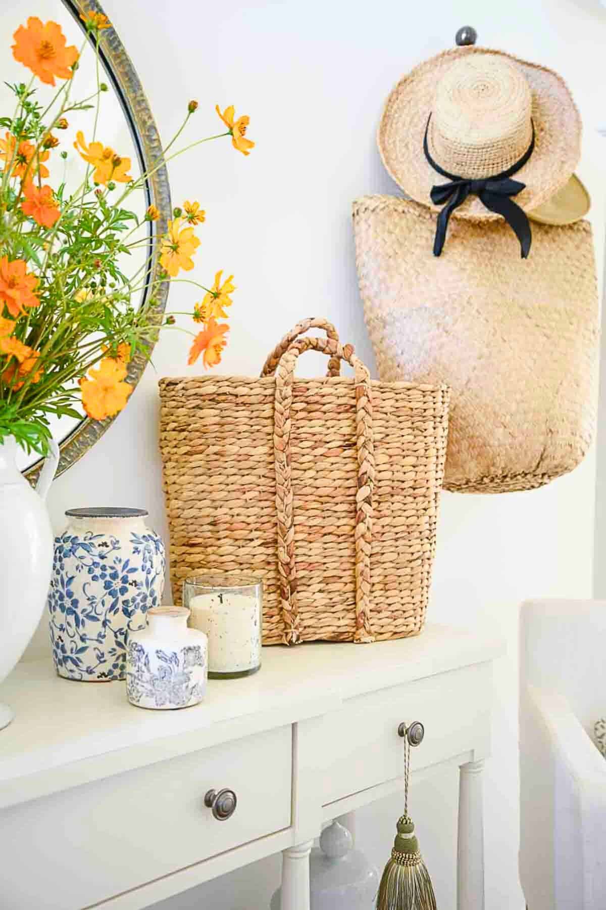 summer foyer table with baskets and a straw hat