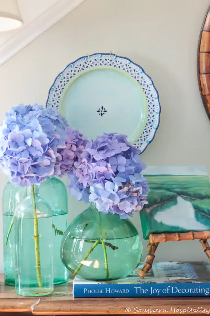 blue hydrangeas in green bottles
