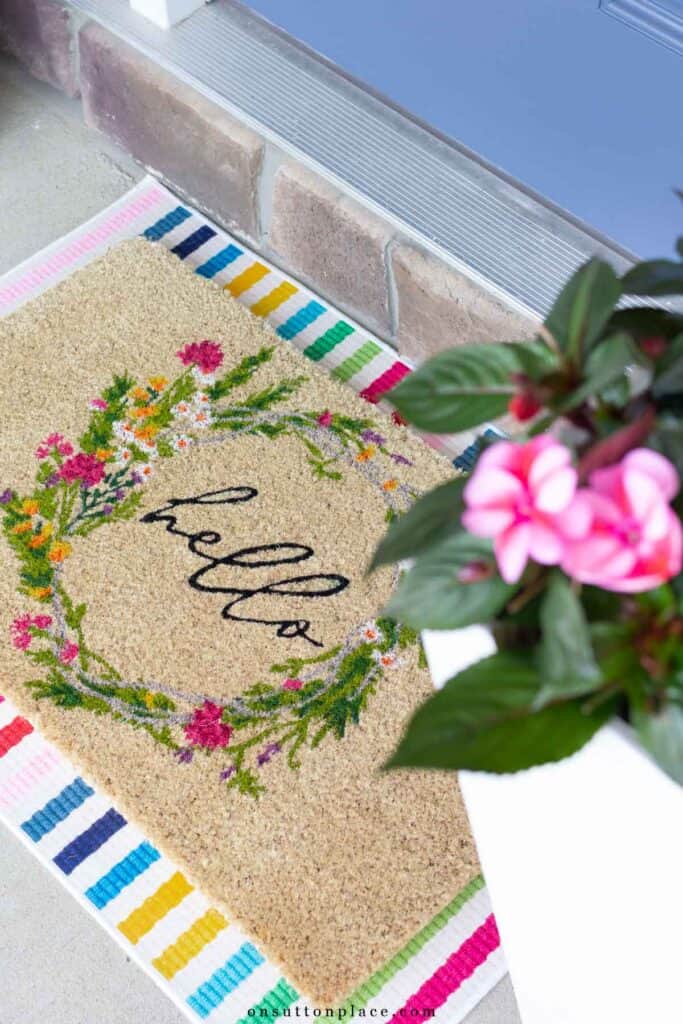 colorful door mat with striped rug under it
