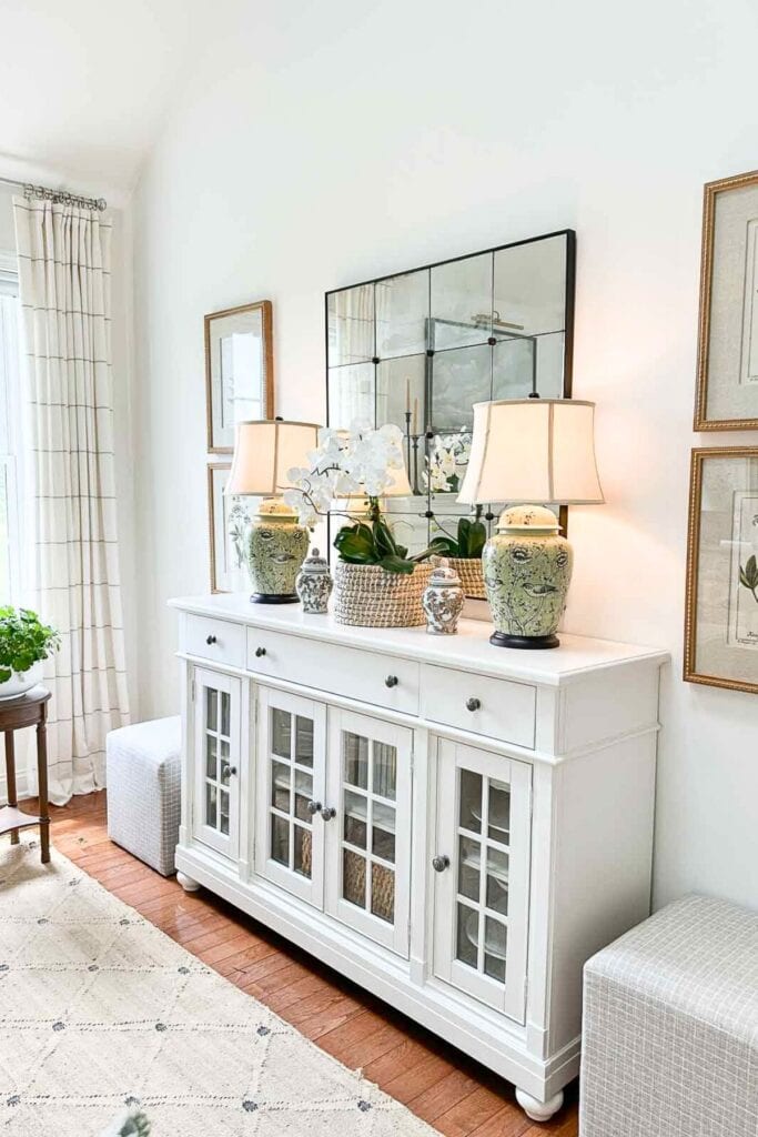 pair of botanical pictures on the side of the white buffet