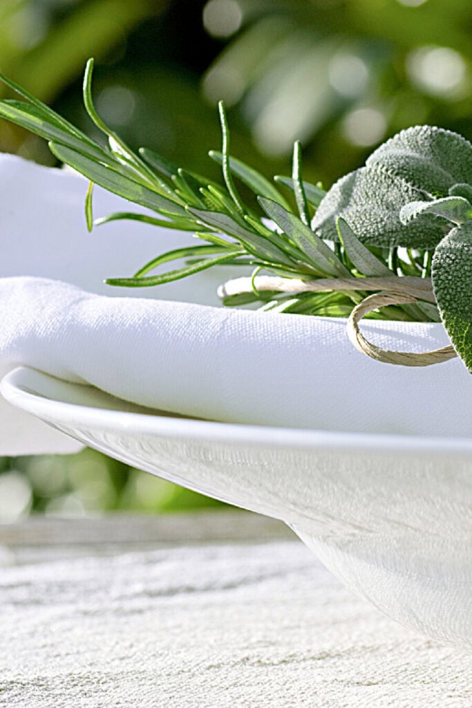 herbs and a white napkin on a bowl