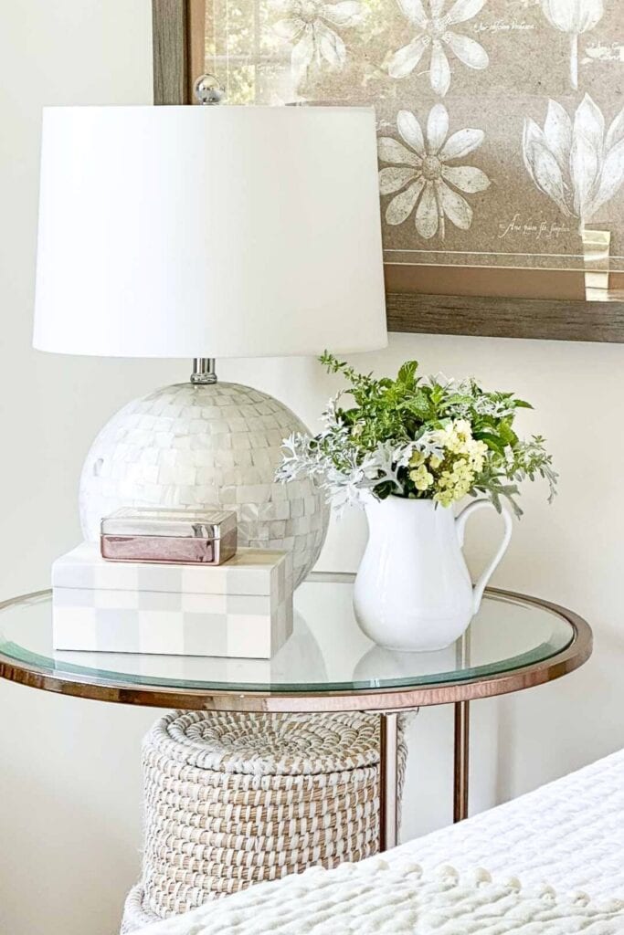 round glass nightstand next to bed