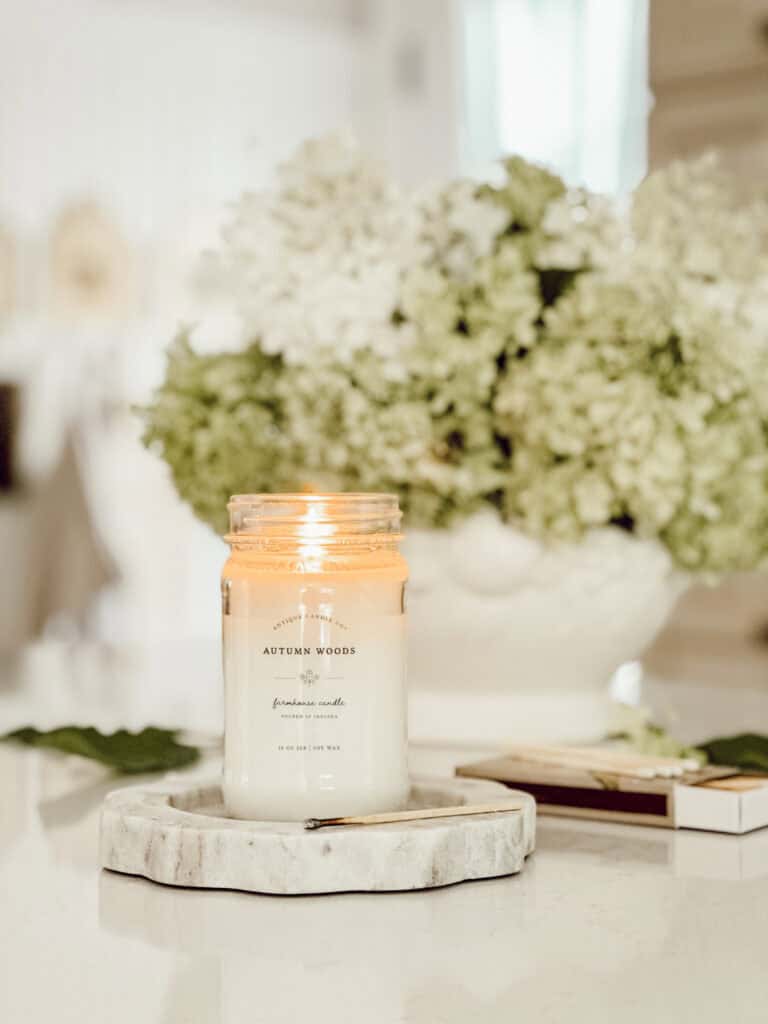 candle with a urn of hydrangeas in the background