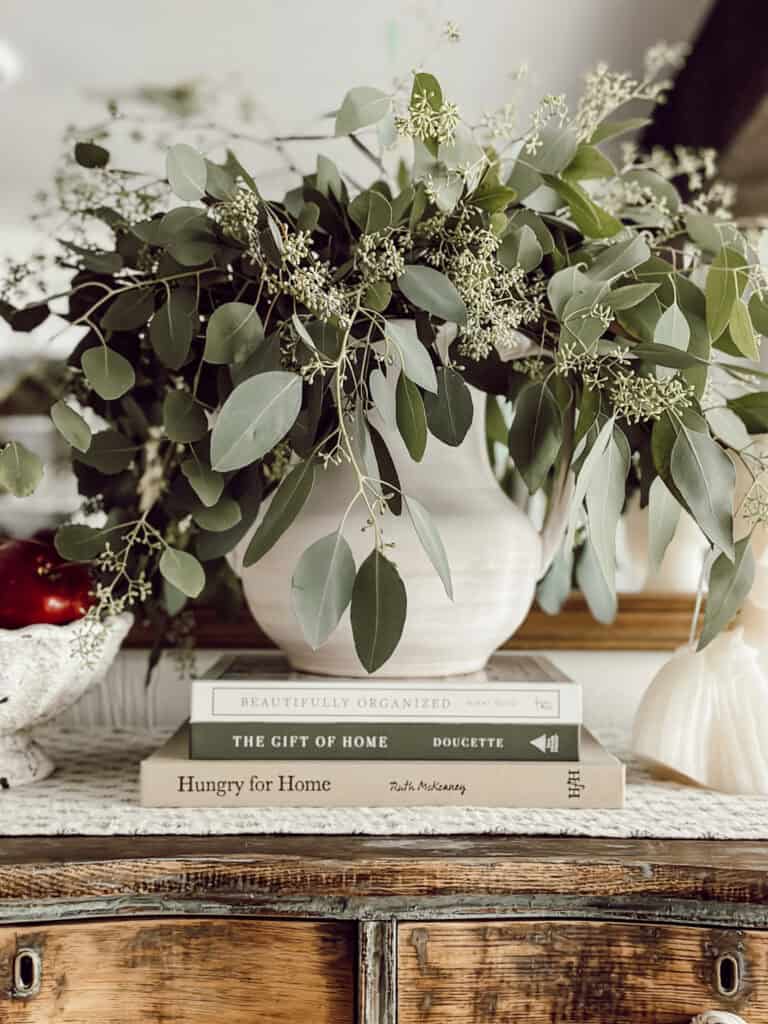 vase with eucalyptus on a stack of books