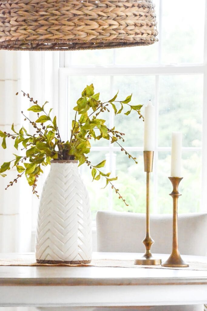 greens in a tall vase on a dining room table
