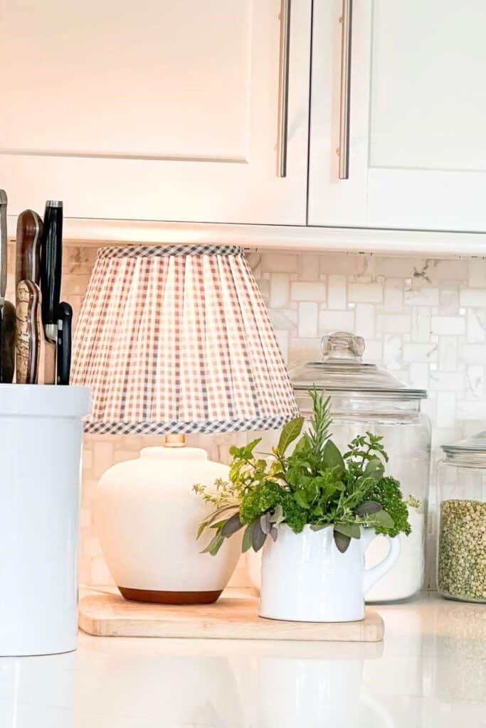 lamp in the kitchen on and a crock of freshly picked herbs next to it.