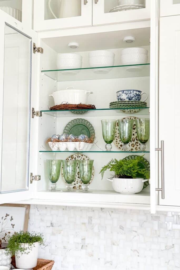dishes and glassware displayed in glass front cabinets in a kitchen