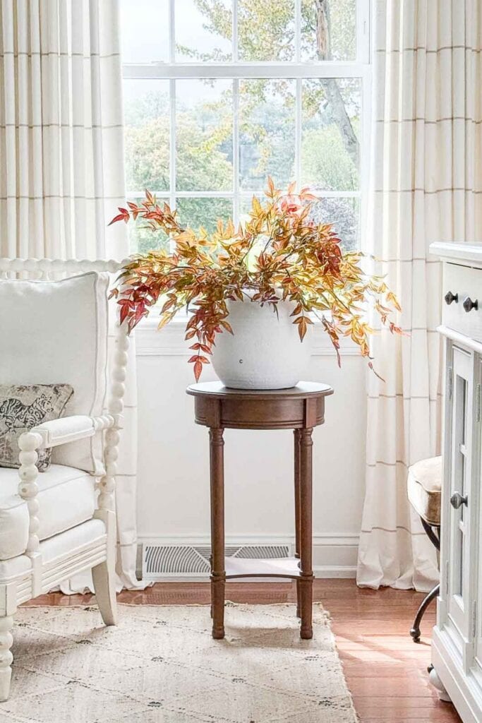FALL BRANCHES WITH LEAVES IN A WHITE BOWL ON A PEDESTAL