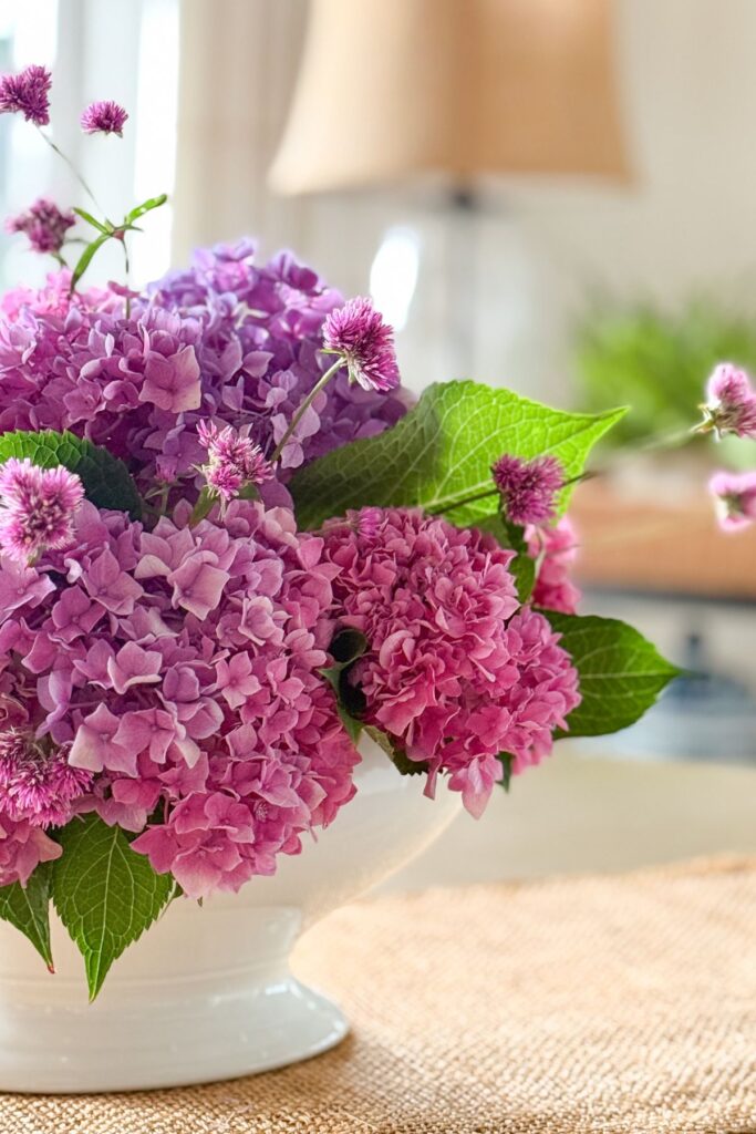 Purple and pink bigleaf hydrangeas arranged in a white ironstone soup tureen for fall decorating.