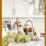 Bright white kitchen with elegant decor, fresh flowers, and modern fixtures. Perfect for cozy, stylish home design inspiration.