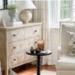 Cozy living room decor with a light beige dresser, decorative table, and elegant accents for a inviting home atmosphere.