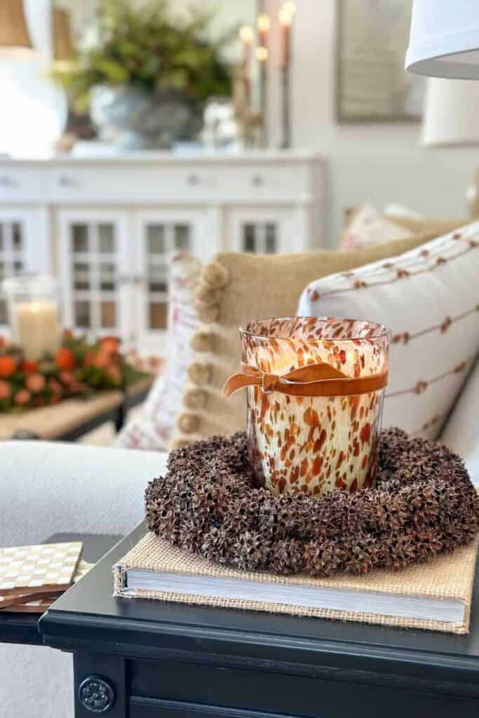 Sweet gum ball wreath repurposed as a candle ring for budget friendly fall decorating.
