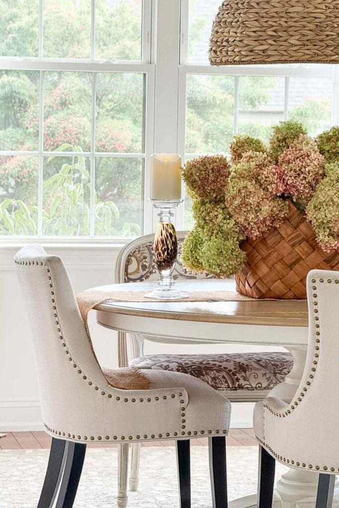 dried hydrangeas in a basket on a dining room table