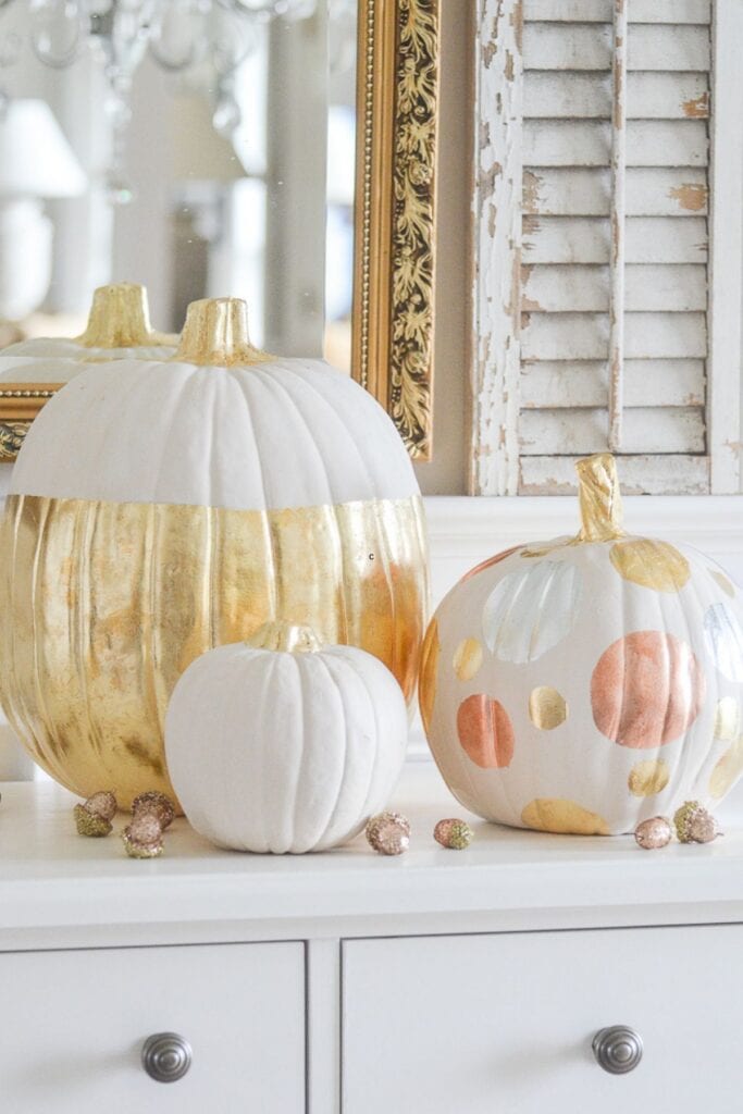 White and gold painted pumpkins styled on a console table for neutral and elegant fall decorating without orange.