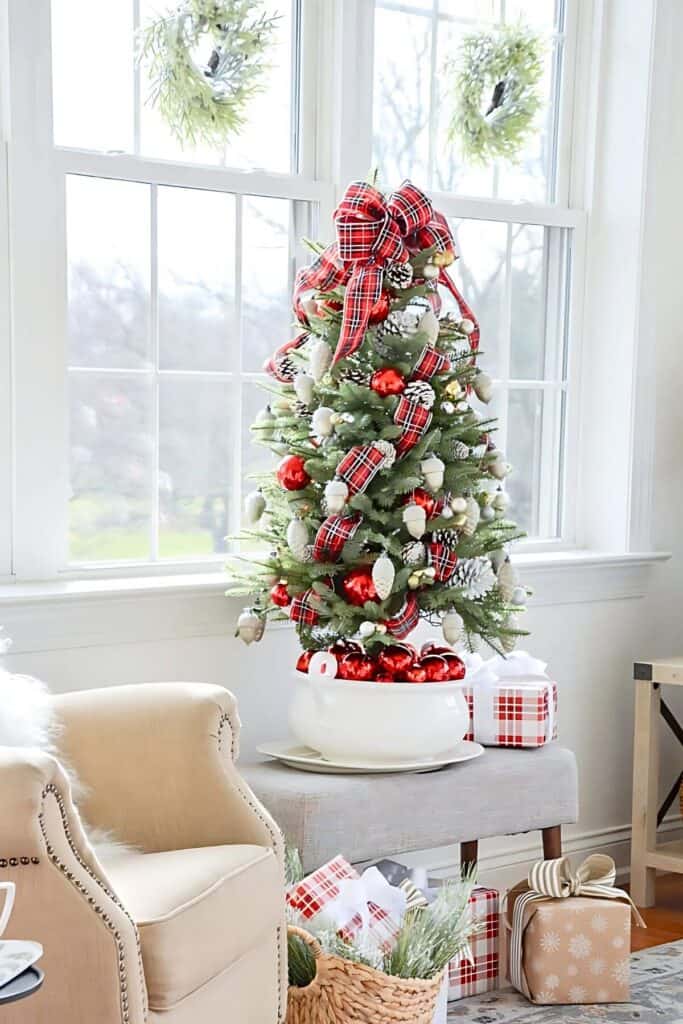 decorating trend featuring a small plaid-decorated tree in a cozy living room, showing the idea of adding a tree in every room.