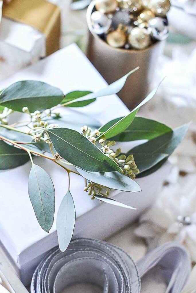 Christmas 2025 decorating trend featuring eucalyptus foliage, silver ribbon, and gold ornaments for a fresh, natural holiday look.
